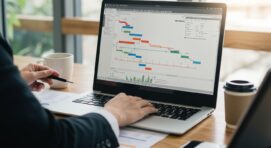 A professional working on a Gantt chart displayed on a laptop screen, analyzing project timelines and tasks in a structured format.